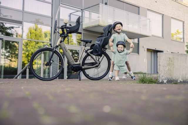 twee broertjes met fietshelmen naast fiets